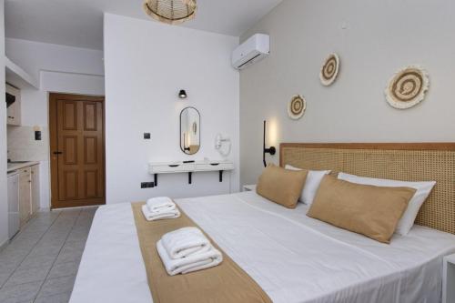 a bedroom with a large white bed with towels on it at Electra Studios in Palaiochóra