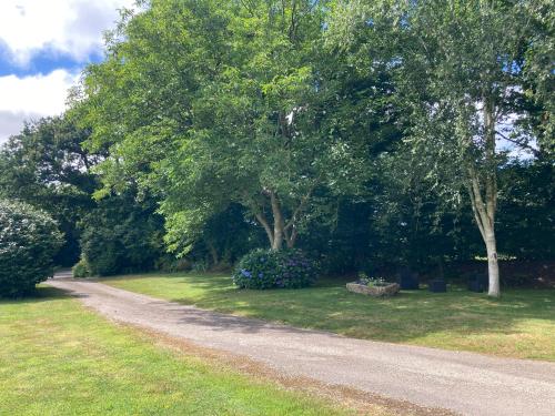 a dirt road in a yard with trees and flowers at Gîte de Kermoal-location de vacances in Poullan-sur-Mer