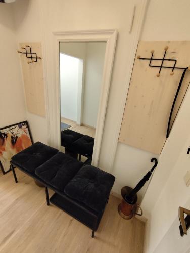 a living room with a black couch and a mirror at Alberthof Zittau in Zittau