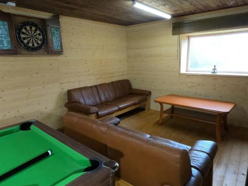 a living room with a couch and a pool table at VitaNorse AB in Älglund
