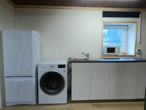 a kitchen with a washing machine and a window at VitaNorse AB in Älglund