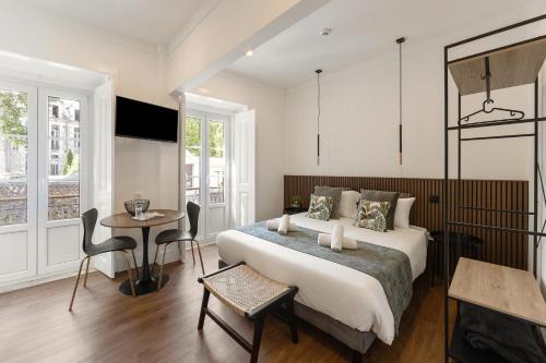 a bedroom with a bed and a table and chairs at Solar das Termas in Caldas da Rainha