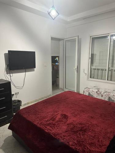 a bedroom with a bed and a flat screen tv at Paradise in Bin Rhilouf