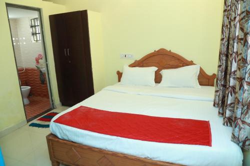 a bedroom with a large bed with a red blanket at Sky Touch Inn in Yercaud