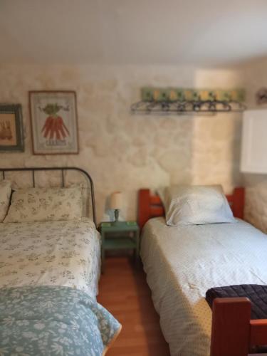 a bedroom with two beds and a small table at Quinta da Maínha - Charming Houses - Escape to Nature in Braga