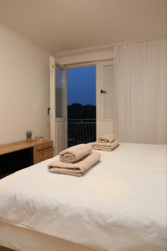 a bedroom with a white bed with towels on it at Vikendica Sara in Šipovo