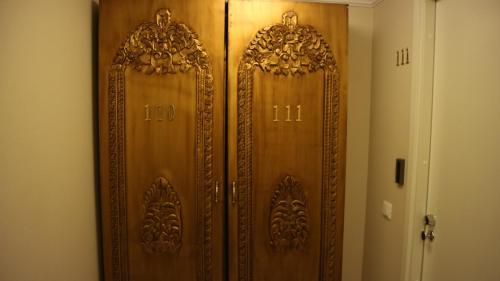 a wooden door with ornate designs on it in a room at Mango Hotel in Tampere