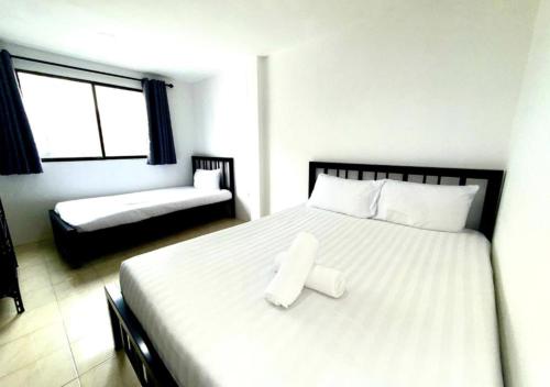 a bedroom with a large white bed with a stool on it at Patong Canal Villa R312 in Patong Beach