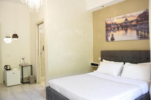 Un dormitorio con una cama y un cuadro en la pared. en Saint Peter Elegance Suite, en Roma