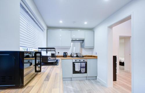 a kitchen with white cabinets and a black refrigerator at Sleek 3 Bedroom Home Sleeps 6 with Parking in Colchester