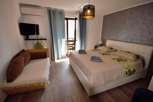 a bedroom with a bed and a couch and a television at Apartments Vretenar in Novigrad Istria