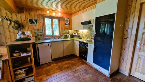 a kitchen with white cabinets and a blue refrigerator at Le Bouquetin - Chalet familial- 8 personnes in Evolène