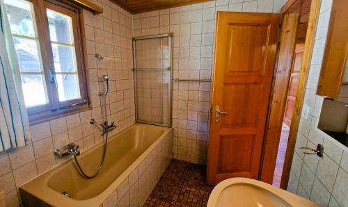a bathroom with a tub and a toilet and a sink at Le Bouquetin - Chalet familial- 8 personnes in Evolène