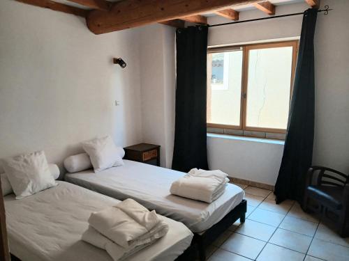 two beds in a room with a window at Maison de village à Riez de 87m2 in Riez