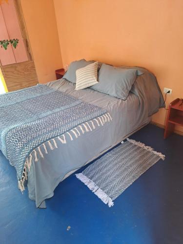 a large bed in a bedroom with a rug on the floor at El jardín secreto Pisco Elqui in Pisco Elqui