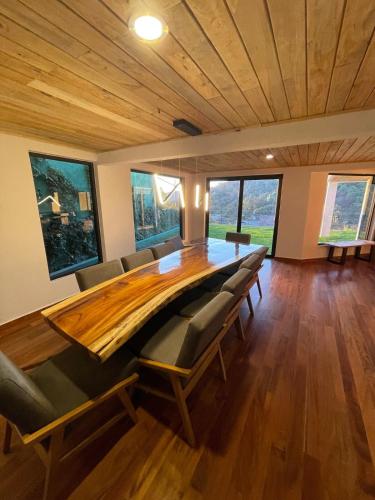 a large dining room with a large wooden table and chairs at LUXO Casa en Valle de Bravo con jacuzzi y espectacular vista al lago in Valle de Bravo