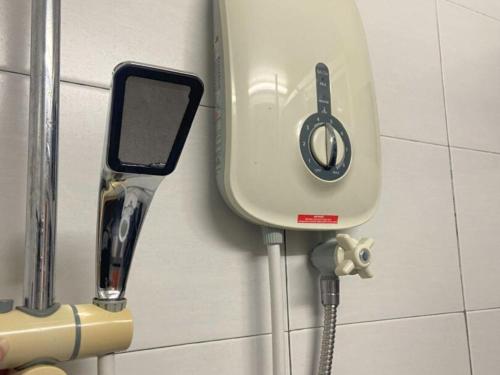 a water tank on a tiled wall with a phone at Minimalist Duplex @ BayanLepas in Bayan Lepas