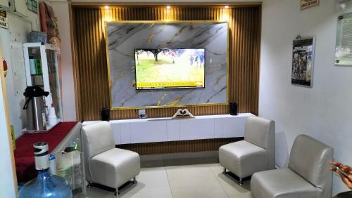 a waiting room with two chairs and a tv on the wall at Hotel plaza centro in Florencia