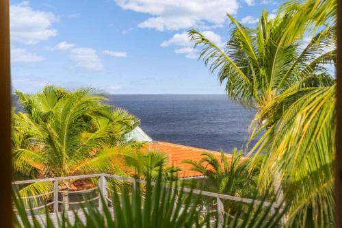 a view of the ocean from a resort with palm trees at Villa Happy Turtle with a spectacular ocean view in Kralendijk