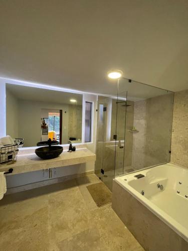 a bathroom with a tub and a sink and a shower at LUXO Casa en Valle de Bravo con jacuzzi y espectacular vista al lago in Valle de Bravo