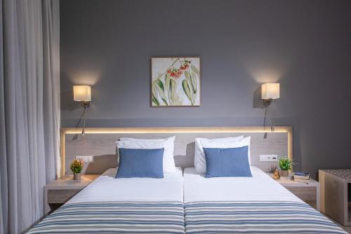 a bedroom with a large bed with two blue pillows at Saint George Gournes Bay in Gournes