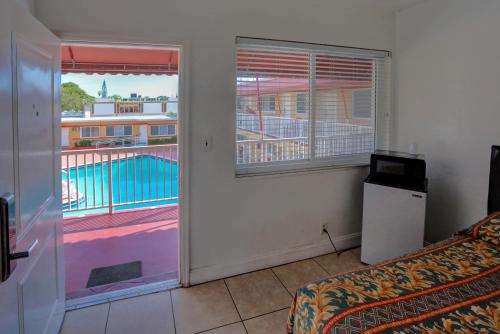a room with a bed and a window with a balcony at Beach and Town Motel in Hollywood