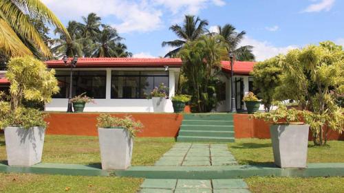 a house with palm trees in front of it at Ranga Holiday Resort in Bentota