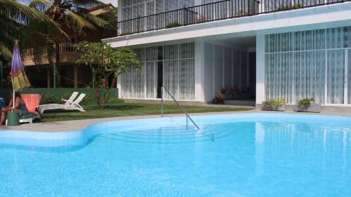 a large blue swimming pool in front of a building at Ranga Holiday Resort in Bentota