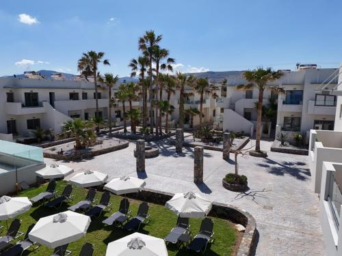 a view of a courtyard with chairs and umbrellas at Saint George Gournes Bay in Gournes