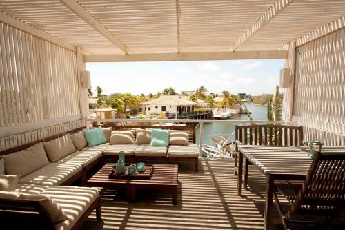 a patio with a couch and tables on a deck at Vista Marina in Kralendijk