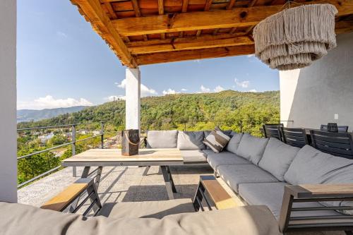 a living room with a couch and a table at LUXO Casa en Valle de Bravo con jacuzzi y espectacular vista al lago in Valle de Bravo
