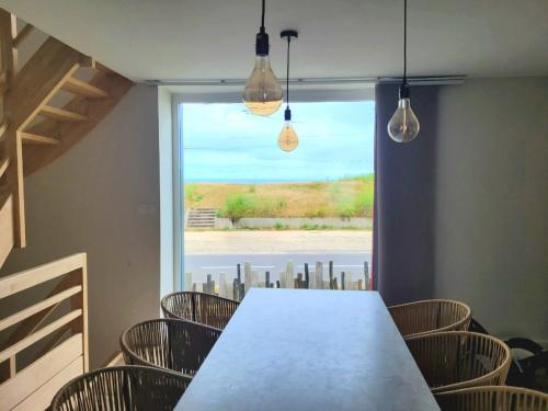 a dining room with a table and chairs and a window at Ti Poulfoen in Plouescat