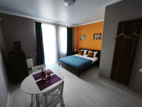 a bedroom with a bed and a table in a room at Sunhouse in Sanzhiyka