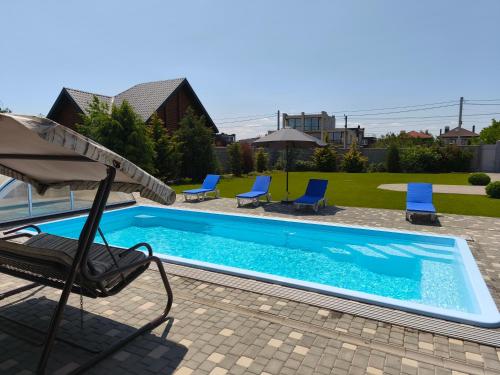 a chair and an umbrella next to a swimming pool at Sunhouse in Sanzhiyka