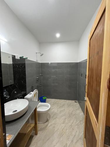 a bathroom with a white toilet and a sink at Honey Bee in Leh