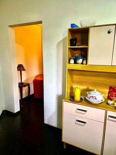 a kitchen with a counter and a shelf with food on it at Capim gordura in Ubatuba