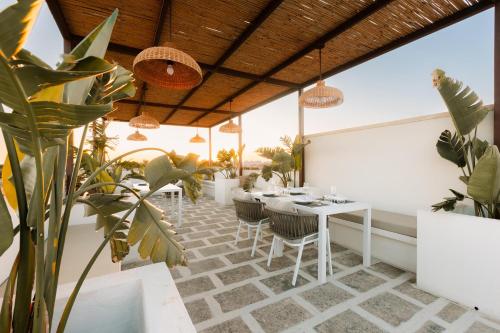 a patio with tables and chairs and potted plants at Dimora Le Tre Muse Guesthouse in Lecce