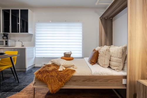 a room with a bed and a kitchen with a window at Spacious Studio on Bishop - Hot Spot Dtown MTL in Montréal