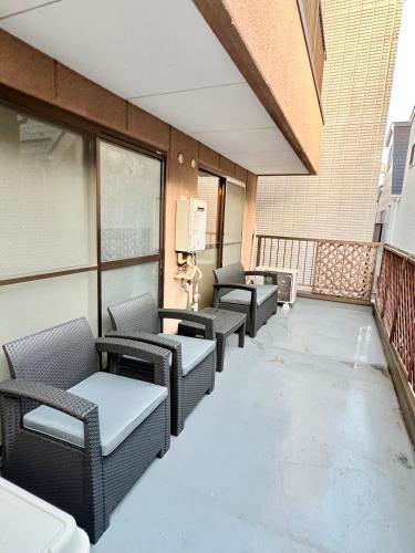 a row of chairs and tables on a balcony at ペットと泊まれる Tatami & B 池上 202 2DK 40m2 in Tokyo