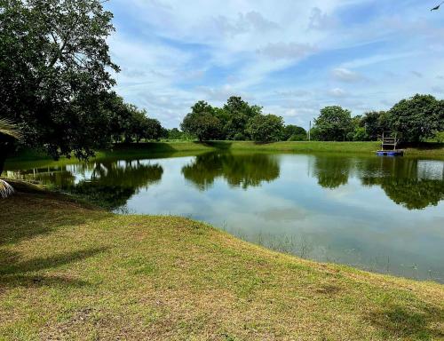 a lake with a boat in the middle of it at Rawinnipha's Resort & Garden Khonkaen in Khon Kaen