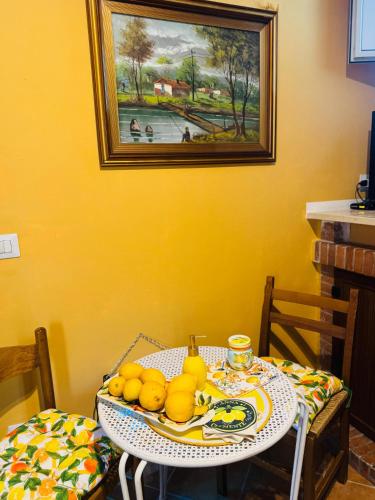 a dining room table with a plate of lemons on it at Casa limone Anna e Clemente Cilento in Sapri