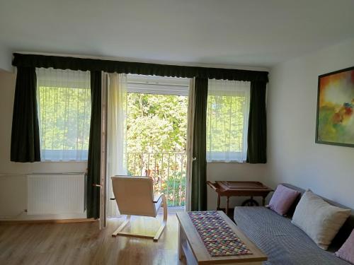 a living room with a couch and a window at City-Apartman in Kaposvár