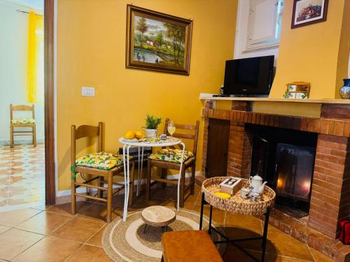 a living room with a fireplace and a table and chairs at Casa limone Anna e Clemente Cilento in Sapri