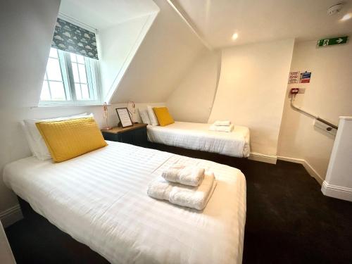 a room with two beds with towels on them at The Stag Rooms in Stratford-upon-Avon