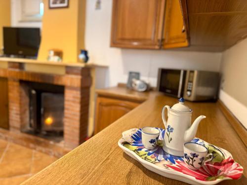 a table with two cups and a tea set on a plate at Casa limone Anna e Clemente Cilento in Sapri