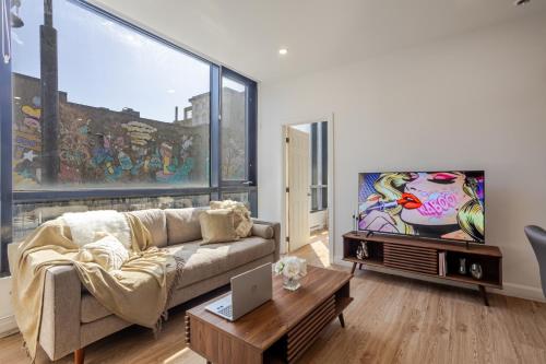 a living room with a couch and a tv at Cute 1BDR Apt on Bishop St- Heart of MTL in Montréal