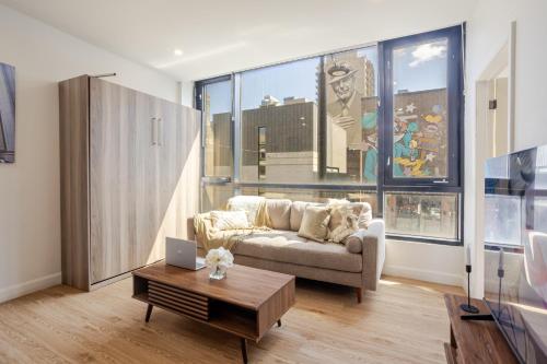 a living room with a couch and a table at Cute 1BDR Apt on Bishop St- Heart of MTL in Montréal