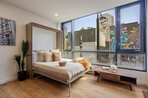 a bedroom with a bed and a large window at Cute 1BDR Apt on Bishop St- Heart of MTL in Montréal