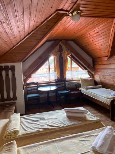 a attic room with two beds and a table at Complex Popangelov in Borovets