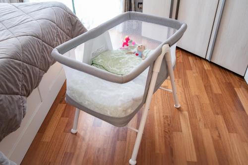 a baby crib sitting next to a bed at Luxury House con WiFi and free parking in Trezzano sul Naviglio